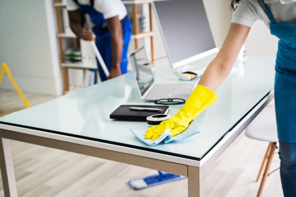 two cleaners cleaning the office table and floor