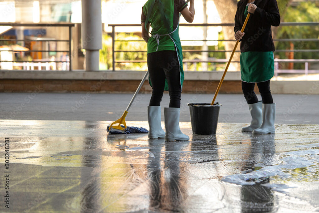 Two women mopping the ground floor