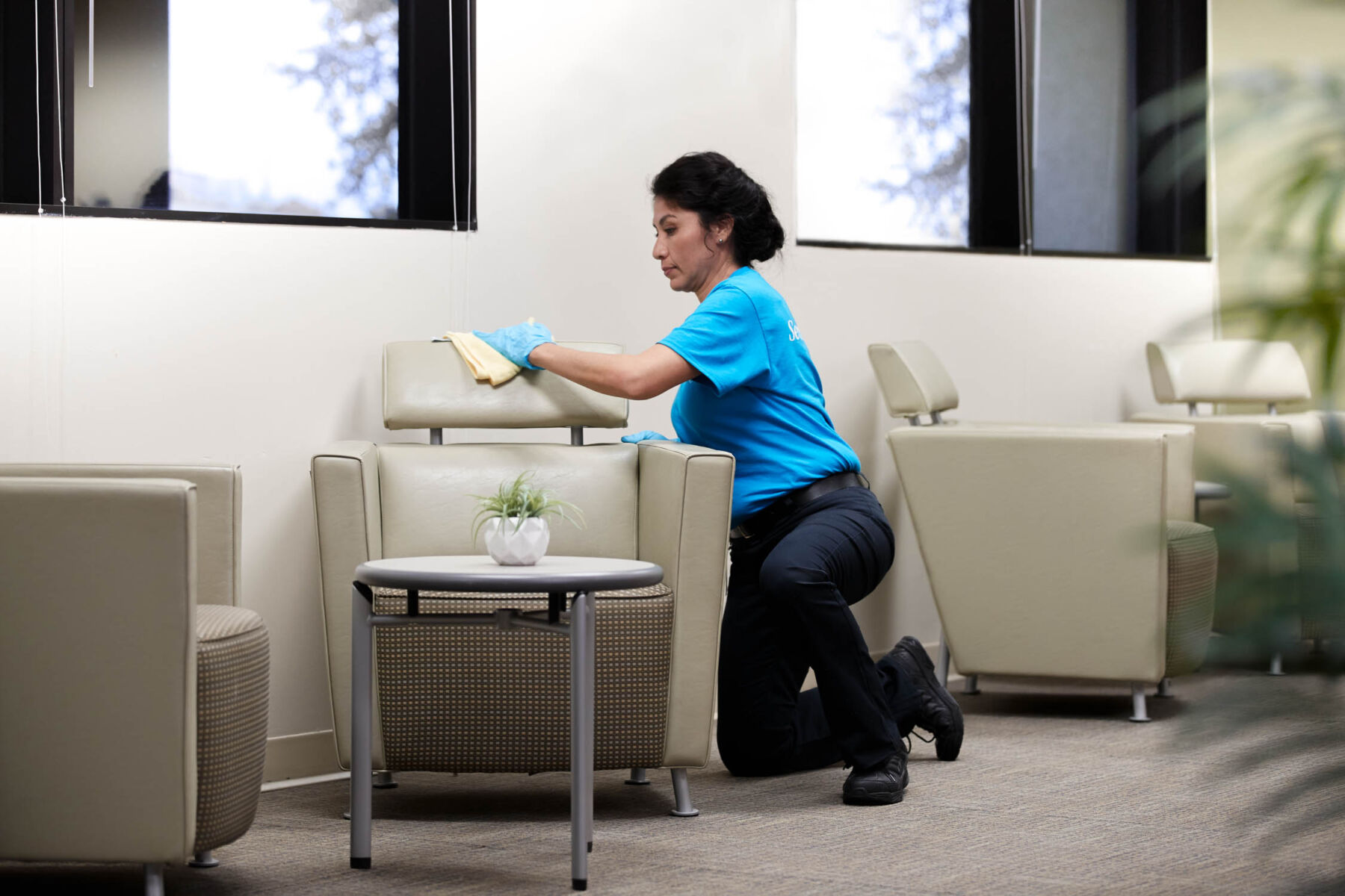 Woman cleaning the sofa kneeling