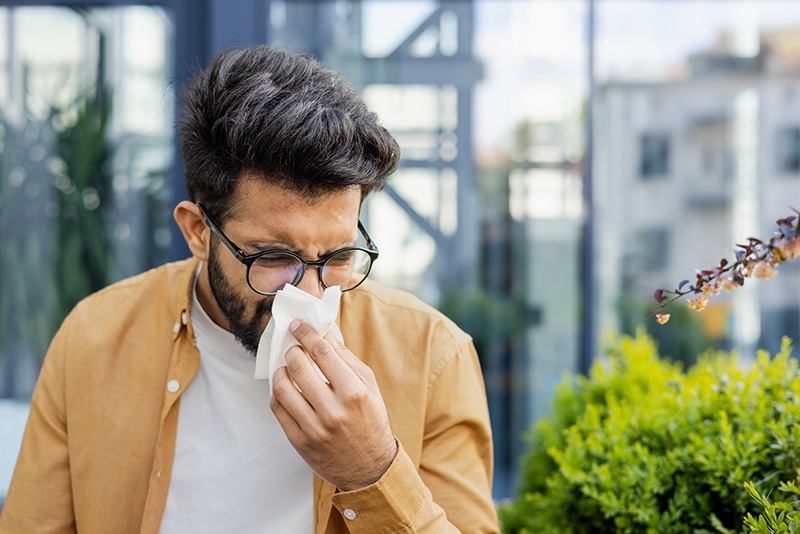 A dallas professional sneezing from pollen and other allergens in the air.