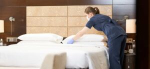 hotel cleaner arranging bedroom pillows