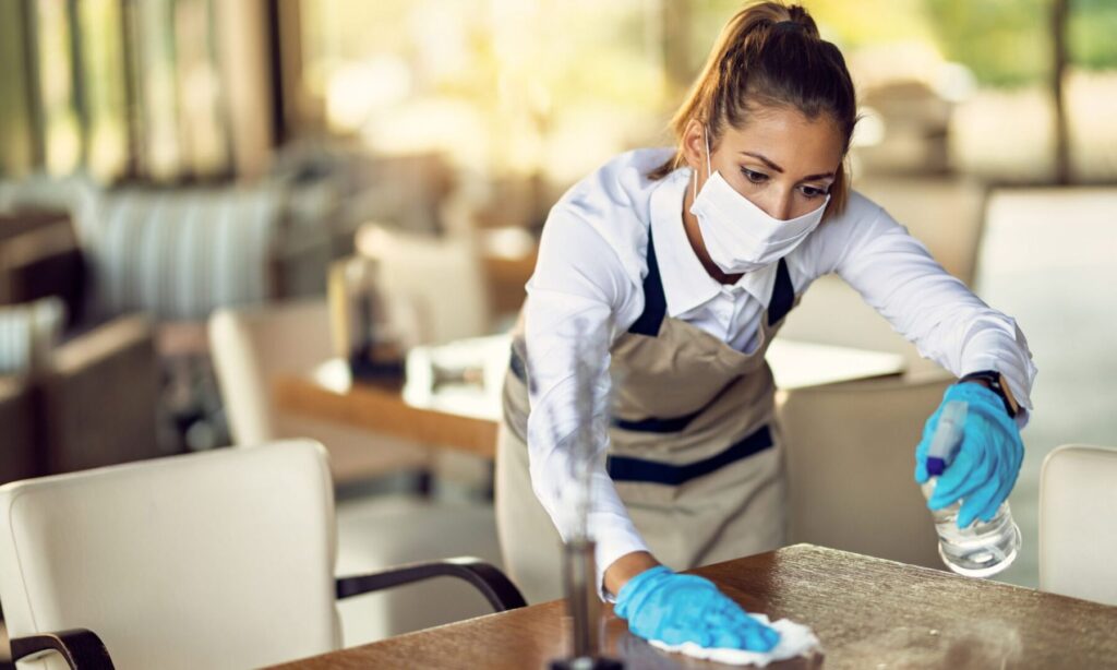 woman disinfecting the tables