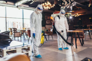 professional cleaners in hazmat suits, disinfecting a commercial place