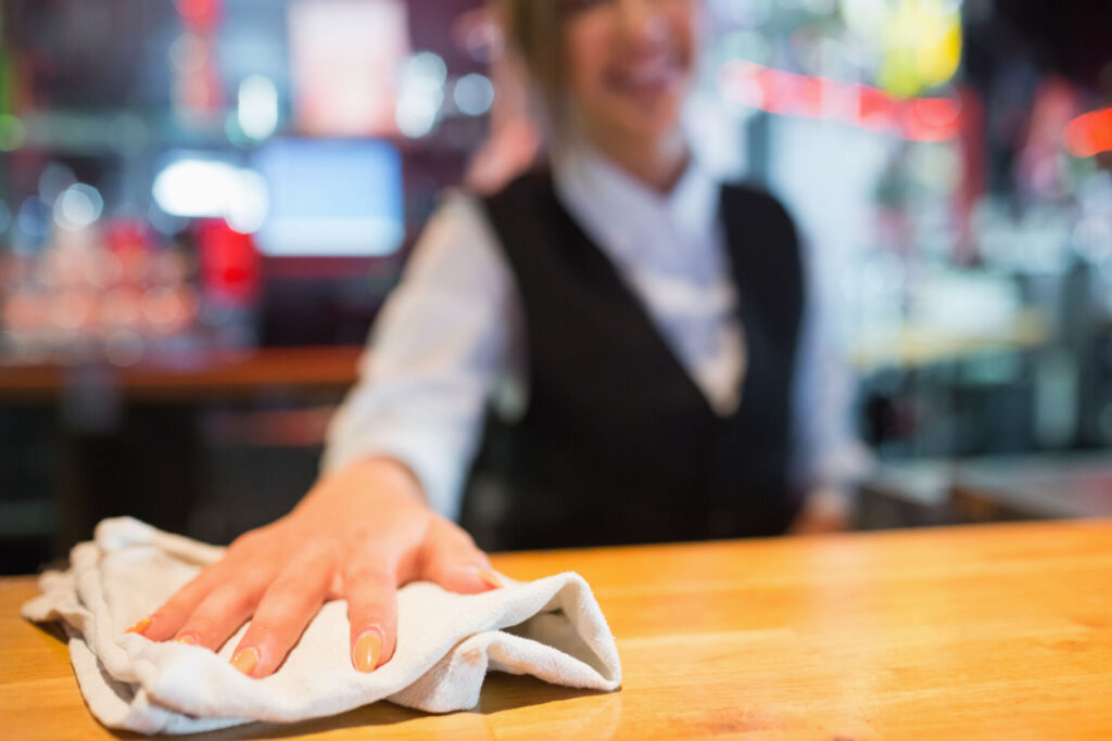 A woman deep cleaning a table in the restaurant