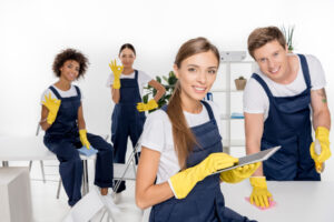 four young cleaners happily pose after cleaning