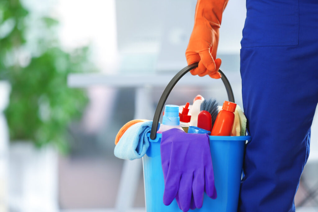 A professional cleaner cleaning a medical office with cleaning supplies, relevant to complete medical office cleaning guide