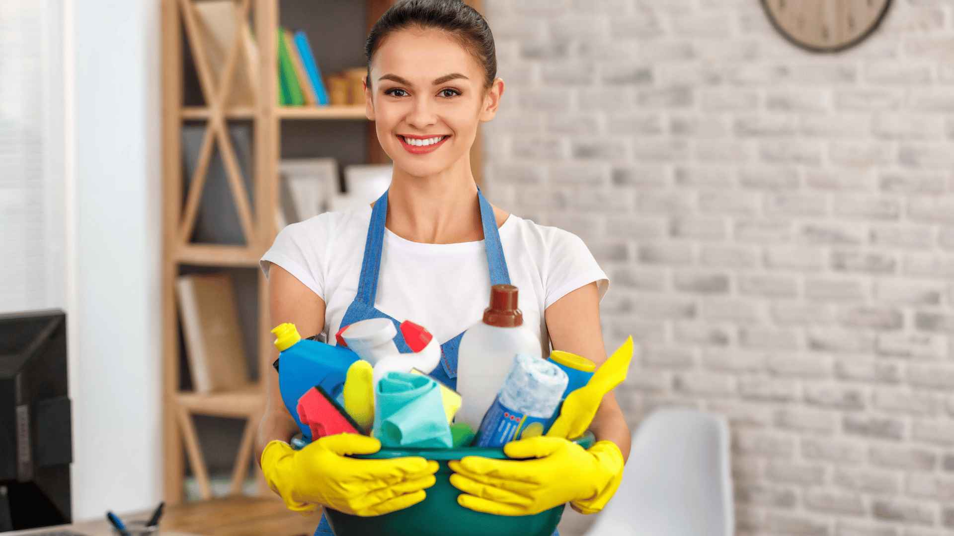 pretty young cleaner smiling while holding the cleaning materials