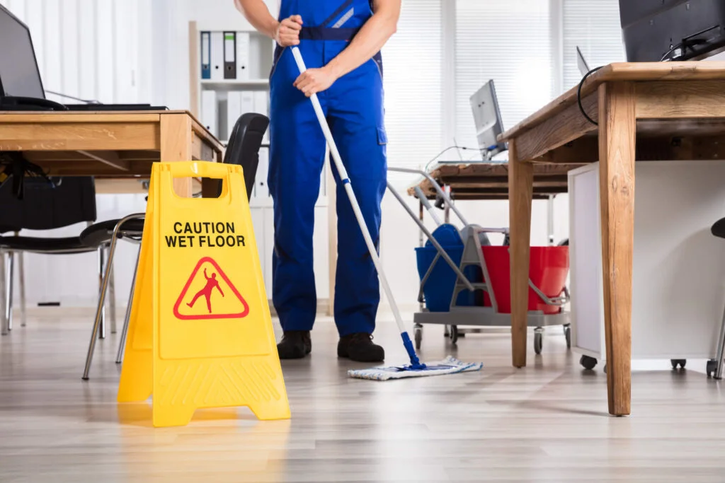 A professional cleaner mopping the office with office cleaning supplies and equipment