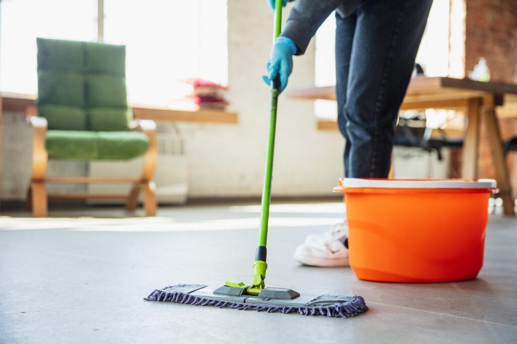 Image of commercial tile floor mopping by a janitorial cleaner, relevant to step-by-step cleaning guide