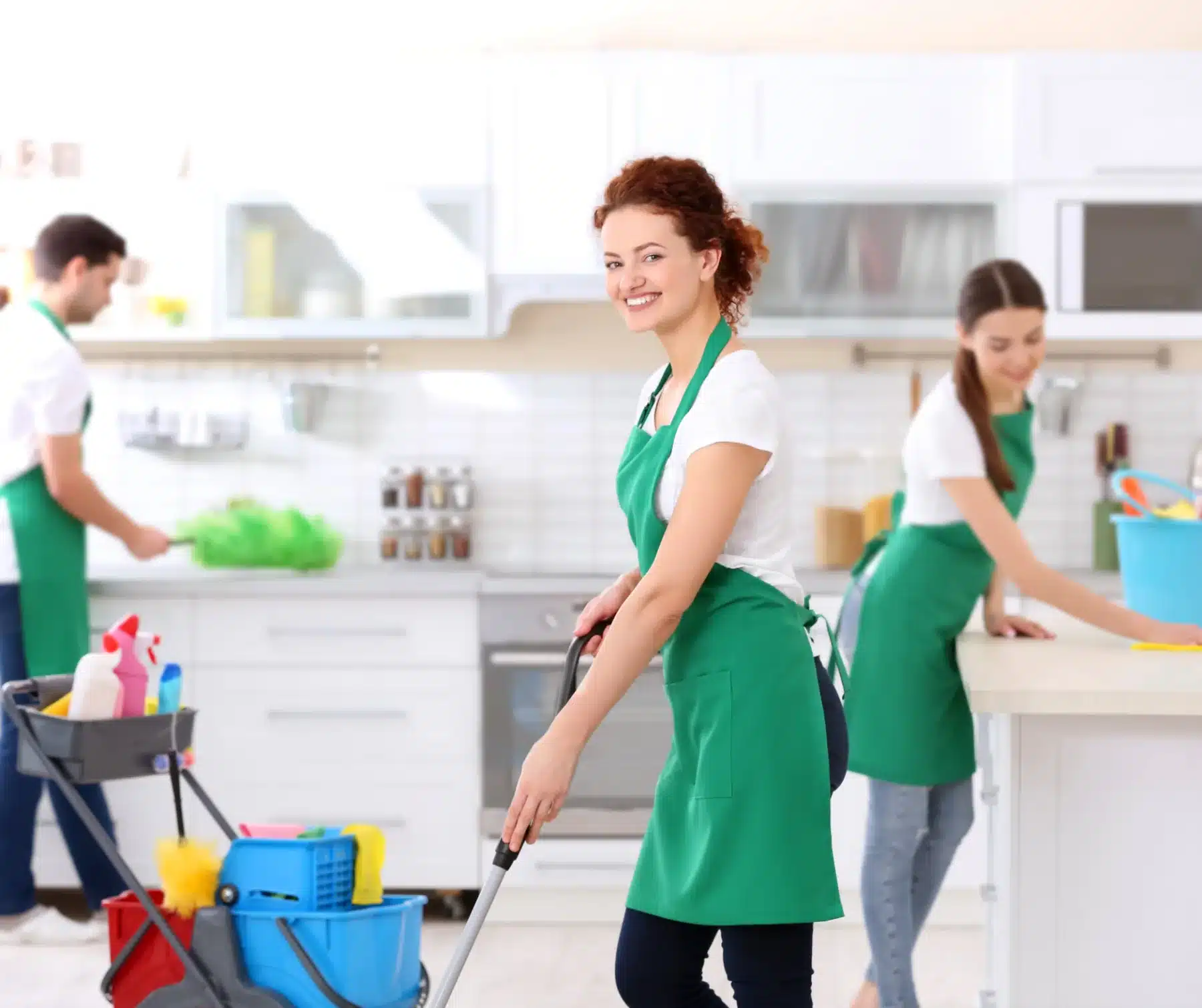 Three people cleaning in kitchen