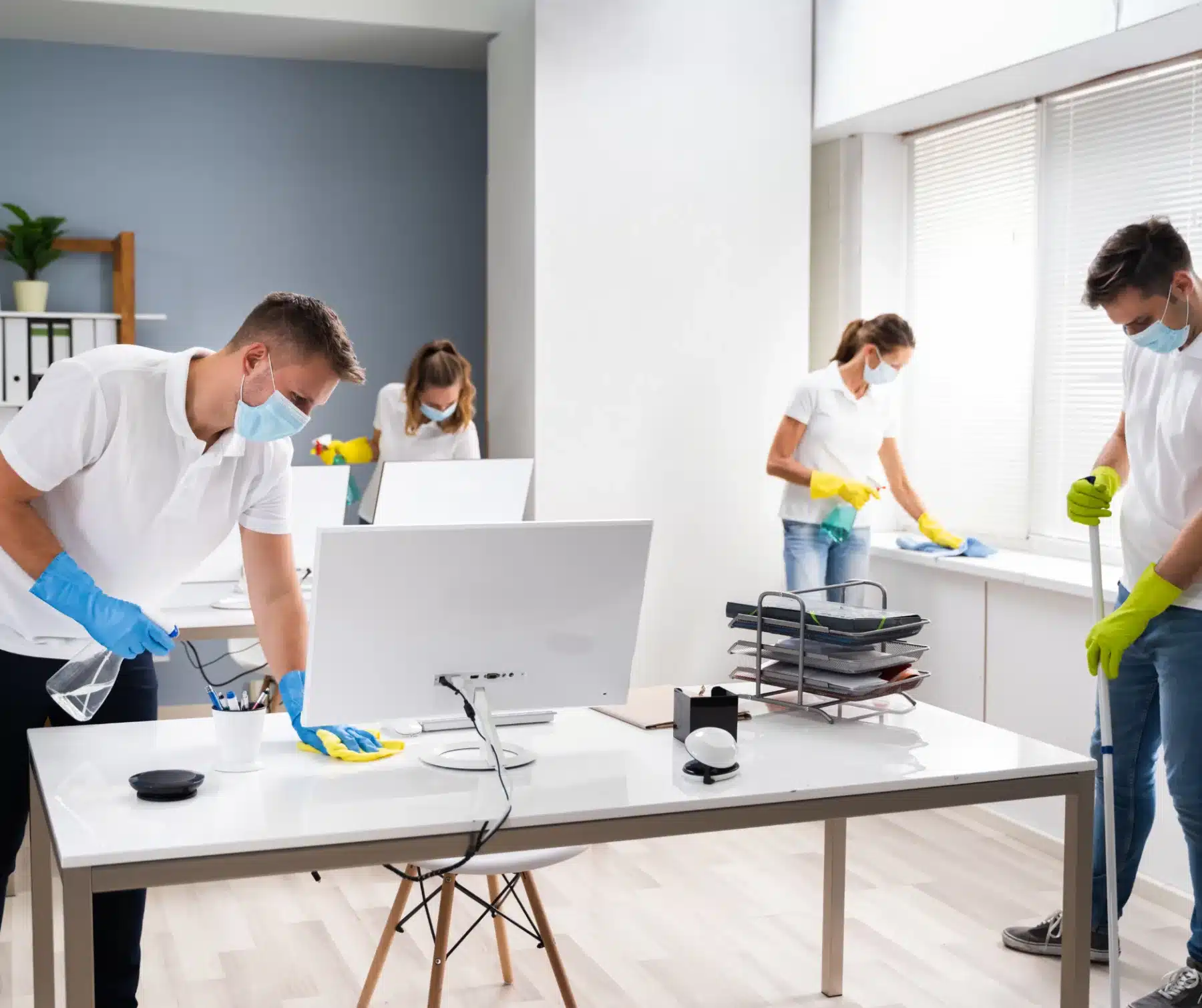 Four people meticulously cleaning in a office room