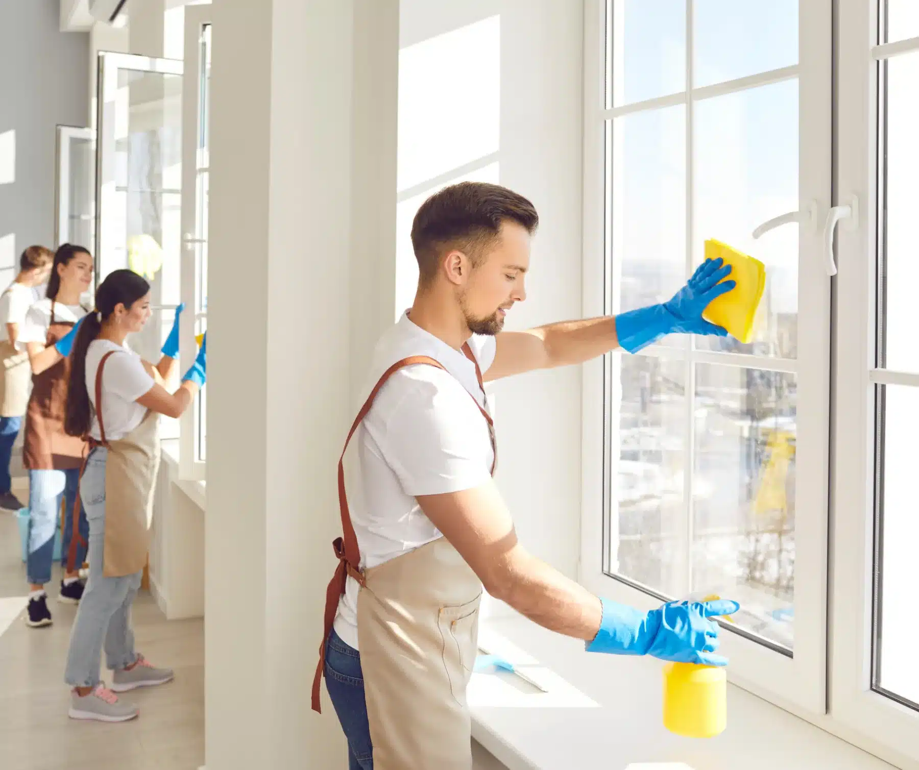 Four people meticulously cleaning the windows