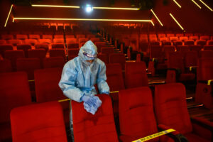 Movie Theater Cleaning Professional in Dallas Wiping Theater Chairs After A Showing