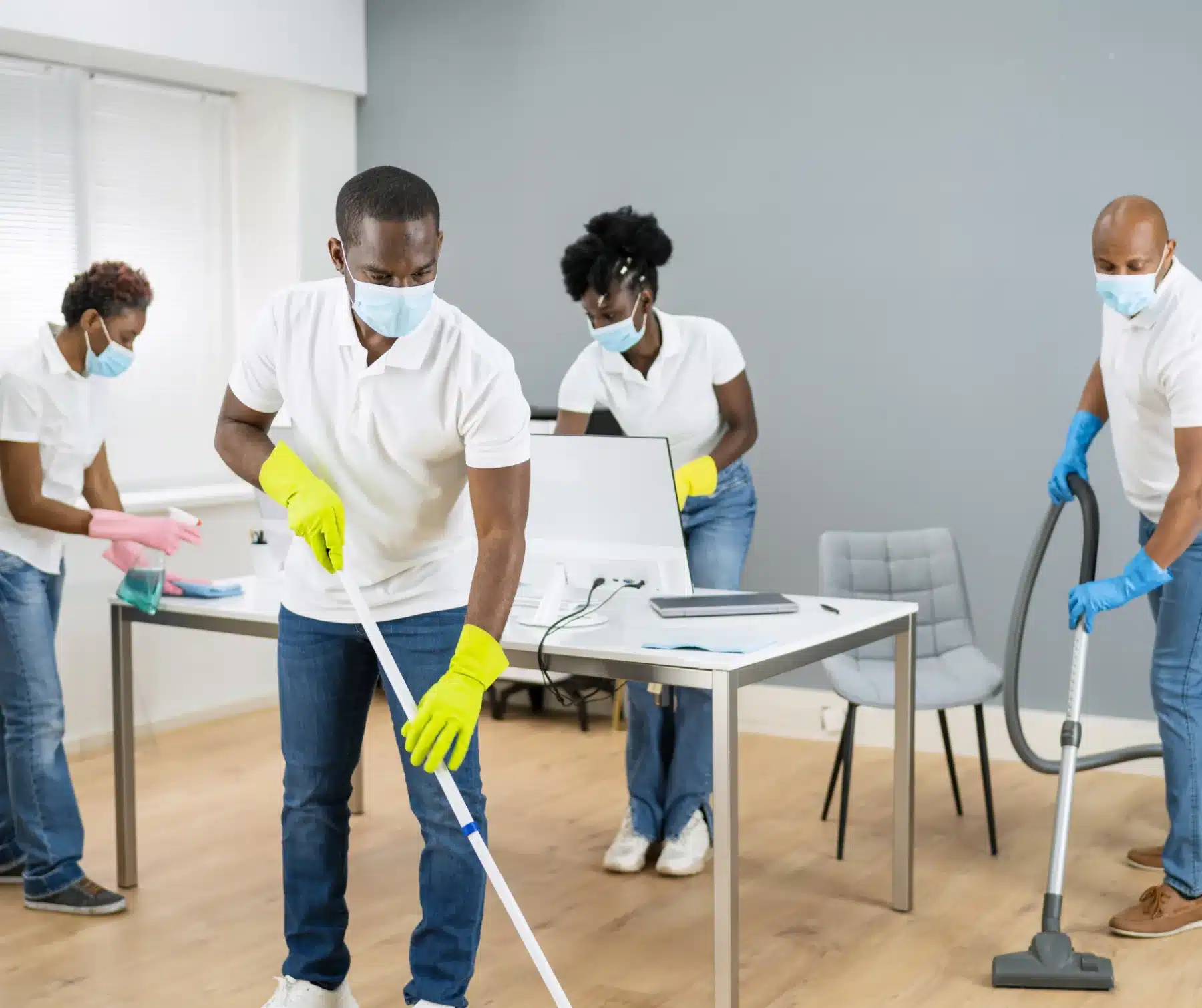 Four people cleaning in a office room