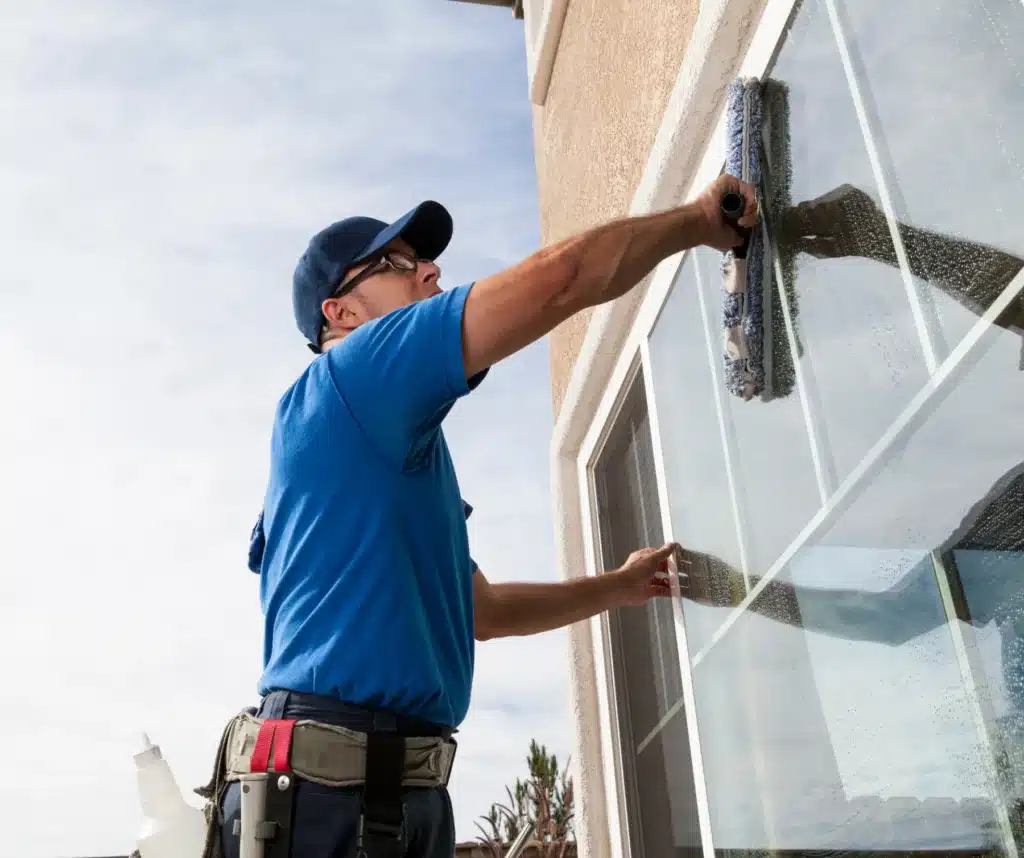 man cleaning outside window