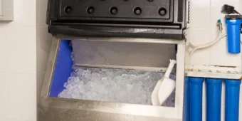 commercial ice machine with filter system and white plastic scoop