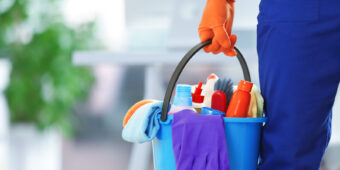 holding cleaning products and tools on bucket, close up