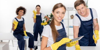 four young cleaners happily pose after cleaning