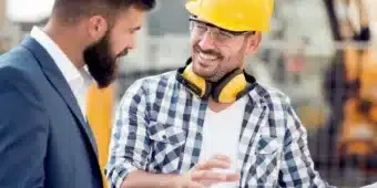 construction site two man talking in a construction site with project plan in their hands