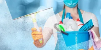 exceptional cleaning service A woman cleaning glass while holding a bucket of cleaning supplies