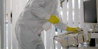 Medical,Worker,In,Ppe,Doing,Sanitization,Of,Equipment,In,Hospital janitor in PPE doing sanitization of equipment in hospital room.