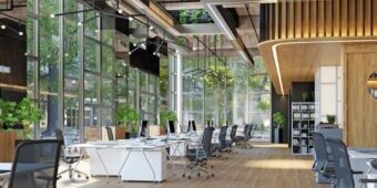 Modern open office with desks, wood floors, and large windows.