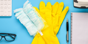 office cleaning tools a pair of gloves and a duster with office supplies