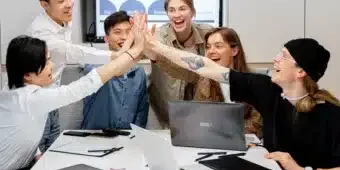 Six people having office meeting and doing high five